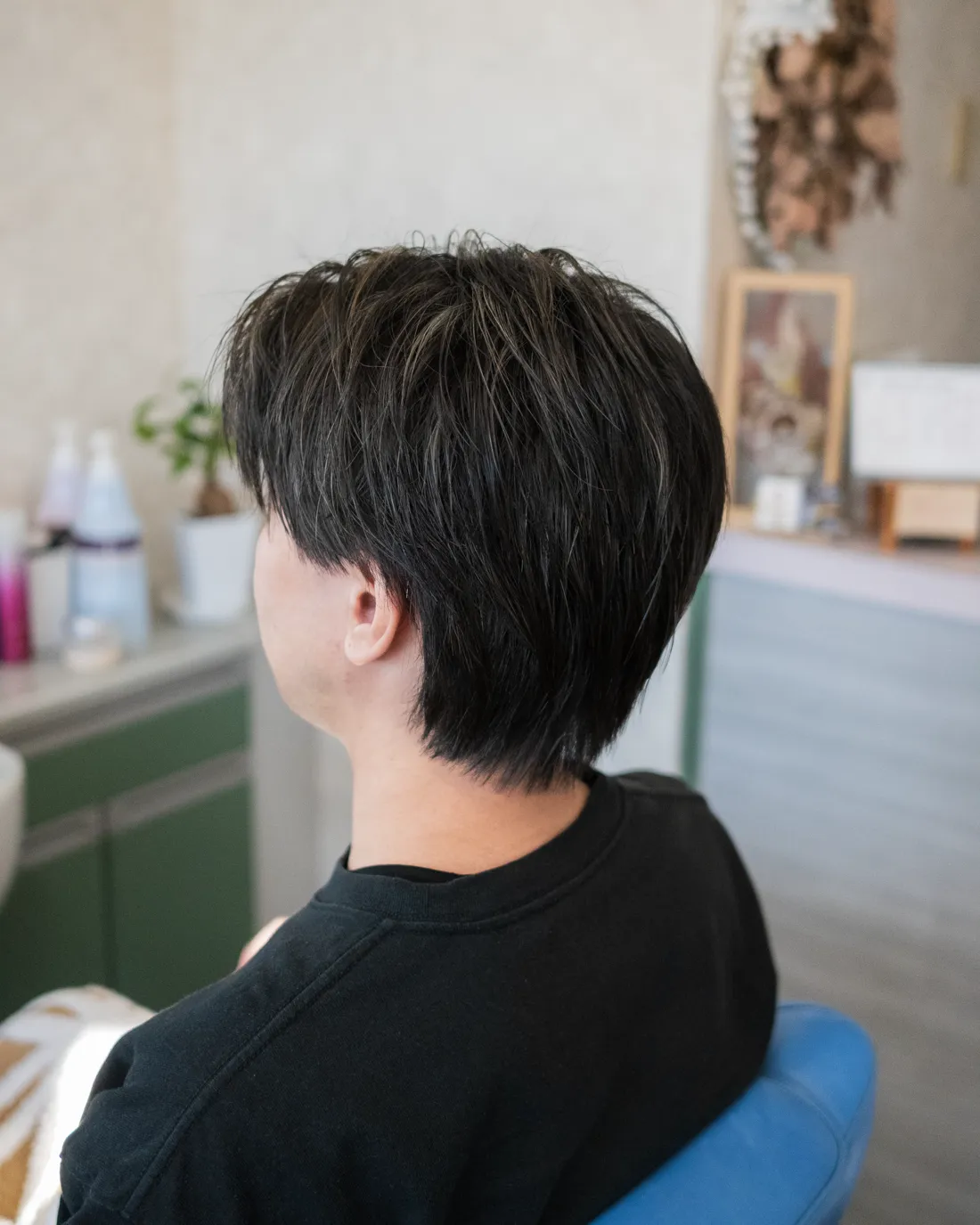 ショートレイヤーのヘアスタイルの男性を左斜め後ろから撮影した写真